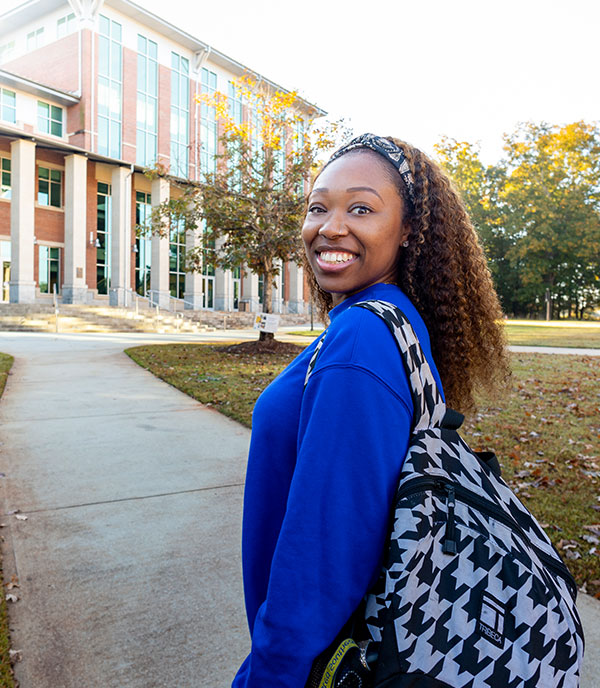 A smiling student looking back on Alpharetta campus
